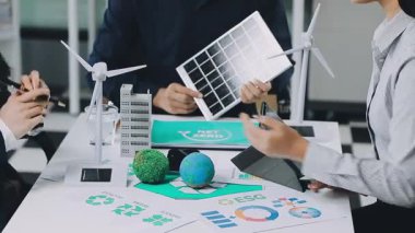 Asyalı kadın mühendis rüzgar türbini ve güneş enerjisi paneli ile güneş paneli tutuyor.