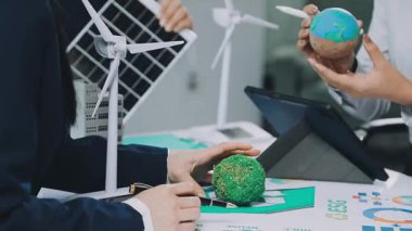 İş adamı ve iş kadını güneş enerjili dünya modelini tutuyor