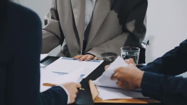 İş adamlarının modern ofiste tartışması ve sözleşmeyi imzalaması.