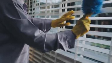 Temizlik, temizlik ve temizlik konsepti. Paçavra, sprey ve lastik eldivenli temizlik servisi. Mavi bir evde pencereyi temizleyen adam..