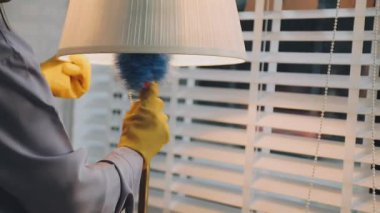 Ofiste pencereyi paçavrayla temizleyen adam, yakın plan.