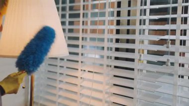 Oturma odasındaki pencereyi temizleyen adam.