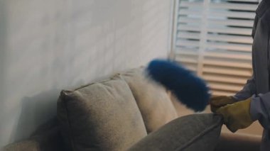 Yakın çekim. Eldivenli adam evde ev işi yapıyor.