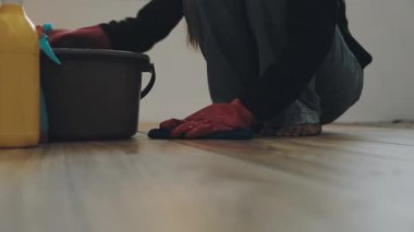 Lastik eldivenli ve kovalı bir adamın temiz zemini var.