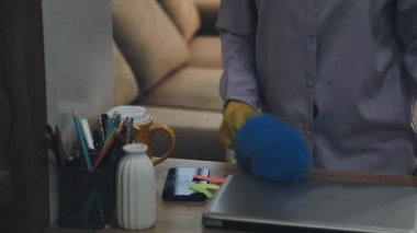 Genç adam ofisteki masayı temizliyor.