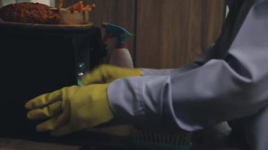 Adam mutfağı süngerle temizliyor..