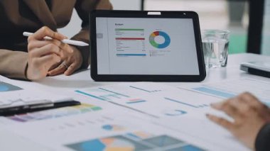 Ofiste grafik grafikli tablet ve tablet bilgisayar kullanan iş kadını.