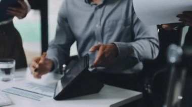 İş adamı masasında bir iş planı yapmak için bir hesap makinesi ve tablet bilgisayar kullanıyor..