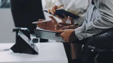 Ofiste bilgisayar ve tabletle çalışan genç adam.