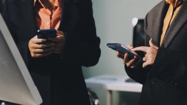 Ofiste otururken akıllı telefon kullanan işadamlarının görüntüsünü kapat.