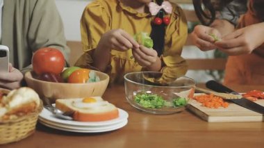 Asyalı genç bir aile birlikte yemek pişiriyor.