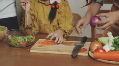 Tahtada sebze doğrayan bir kadın.