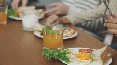 Genç bir kadın tostuyla kahvaltı yapıyor, yakın plan.