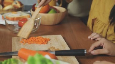 Mutfakta havuç kesen genç bir kadın.