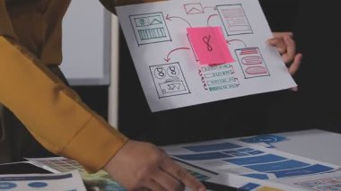 Ofisinde çizelgesi ve çizelgesi olan kadın tasarımcı. Tasarımcı yeni bir tasarım rengi seçiyor