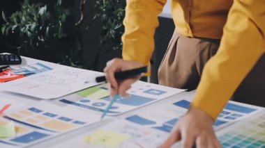 Genç bayan tasarımcı masasında çalışıyor.