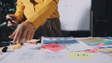 Genç bayan tasarımcı ofiste proje üzerinde çalışıyor.