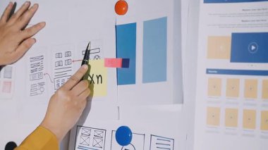 Beyaz takım elbiseli, mavi elbiseli, kalemli genç bir kadın.