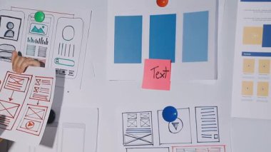 Beyaz tişörtlü, mavi etiketli ve keçeli kalemli bir not defteri olan bir kadın.