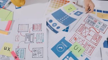 Genç tasarımcı kadın tabletini kullanırken tahtaya yazı yazıyor..