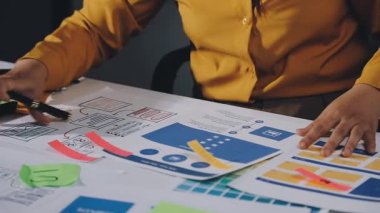 Sarı ve mavi gömlekli genç iş kadını ofiste panoya yazı yazıyor.