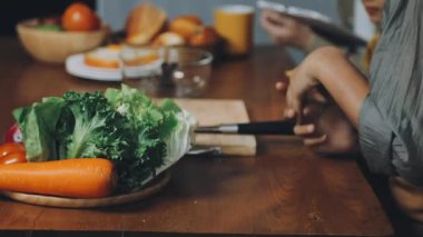 Adam mutfaktaki tahta masada sebze salatası yapıyor.