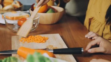 Mutfakta sebze doğrayan genç bir kadın..