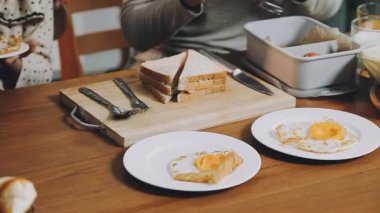 Mutfakta kızarmış ekmekle kahvaltı eden bir kadın.