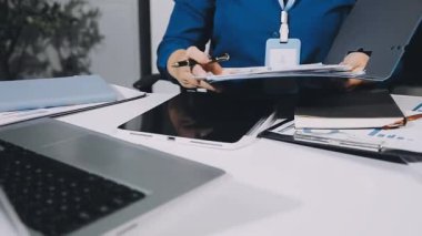 Beyaz gömlekli ve siyah ceketli genç iş adamı tableti üzerinde çalışıyor. İşadamı ofiste.