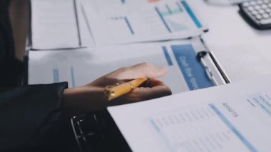 yakın plan - finans tablolarını incelerken kalem tutan işadamının resmi