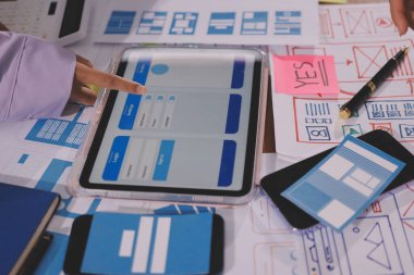 Mobil uygulama arayüzü kablo dizaynı hakkında modern ofisteki müşteri breif ve renk kodu ile fikir alışverişinde bulunan uu geliştirici ve ui tasarımcısını kapat. Yaratıcı dijital geliştirme ajansı.