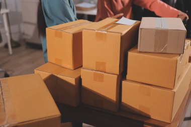 Girişim KOBİ küçük işletme girişimcisi önlük giyen Asyalı kadın dizüstü bilgisayar ve kutu kullanarak çevrimiçi müşterilere, çevrimiçi sme iş fikirlerine satış hazırlamak için siparişleri alır ve gözden geçirir.