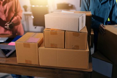 Girişim KOBİ küçük işletme girişimcisi önlük giyen Asyalı kadın dizüstü bilgisayar ve kutu kullanarak çevrimiçi müşterilere, çevrimiçi sme iş fikirlerine satış hazırlamak için siparişleri alır ve gözden geçirir.