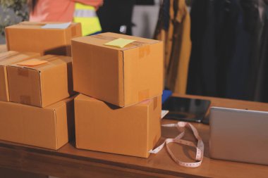 Girişim KOBİ küçük işletme girişimcisi önlük giyen Asyalı kadın dizüstü bilgisayar ve kutu kullanarak çevrimiçi müşterilere, çevrimiçi sme iş fikirlerine satış hazırlamak için siparişleri alır ve gözden geçirir.