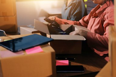 Girişim KOBİ küçük işletme girişimcisi önlük giyen Asyalı kadın dizüstü bilgisayar ve kutu kullanarak çevrimiçi müşterilere, çevrimiçi sme iş fikirlerine satış hazırlamak için siparişleri alır ve gözden geçirir.