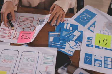 Mobil uygulama arayüzü kablo dizaynı hakkında modern ofisteki müşteri breif ve renk kodu ile fikir alışverişinde bulunan uu geliştirici ve ui tasarımcısını kapat. Yaratıcı dijital geliştirme ajansı.