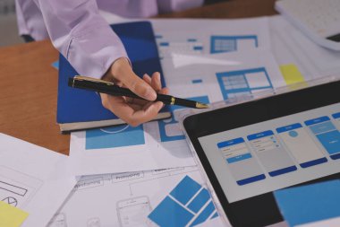 Mobil uygulama arayüzü kablo dizaynı hakkında modern ofisteki müşteri breif ve renk kodu ile fikir alışverişinde bulunan uu geliştirici ve ui tasarımcısını kapat. Yaratıcı dijital geliştirme ajansı.