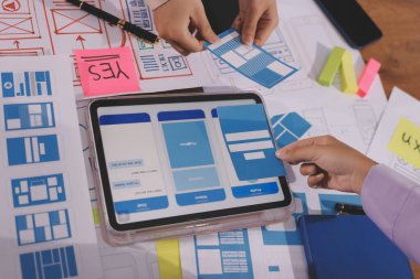 Mobil uygulama arayüzü kablo dizaynı hakkında modern ofisteki müşteri breif ve renk kodu ile fikir alışverişinde bulunan uu geliştirici ve ui tasarımcısını kapat. Yaratıcı dijital geliştirme ajansı.