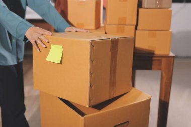 Girişim KOBİ küçük işletme girişimcisi önlük giyen Asyalı kadın dizüstü bilgisayar ve kutu kullanarak çevrimiçi müşterilere, çevrimiçi sme iş fikirlerine satış hazırlamak için siparişleri alır ve gözden geçirir.