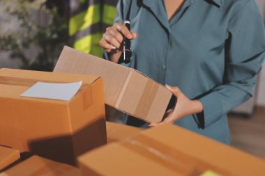 Girişim KOBİ küçük işletme girişimcisi önlük giyen Asyalı kadın dizüstü bilgisayar ve kutu kullanarak çevrimiçi müşterilere, çevrimiçi sme iş fikirlerine satış hazırlamak için siparişleri alır ve gözden geçirir.