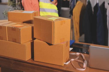 Girişim KOBİ küçük işletme girişimcisi önlük giyen Asyalı kadın dizüstü bilgisayar ve kutu kullanarak çevrimiçi müşterilere, çevrimiçi sme iş fikirlerine satış hazırlamak için siparişleri alır ve gözden geçirir.