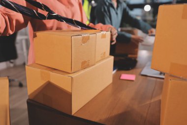 Girişim KOBİ küçük işletme girişimcisi önlük giyen Asyalı kadın dizüstü bilgisayar ve kutu kullanarak çevrimiçi müşterilere, çevrimiçi sme iş fikirlerine satış hazırlamak için siparişleri alır ve gözden geçirir.