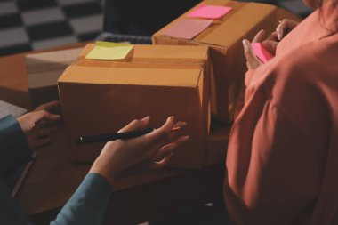 Girişim KOBİ küçük işletme girişimcisi önlük giyen Asyalı kadın dizüstü bilgisayar ve kutu kullanarak çevrimiçi müşterilere, çevrimiçi sme iş fikirlerine satış hazırlamak için siparişleri alır ve gözden geçirir.