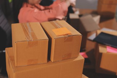 Girişim KOBİ küçük işletme girişimcisi önlük giyen Asyalı kadın dizüstü bilgisayar ve kutu kullanarak çevrimiçi müşterilere, çevrimiçi sme iş fikirlerine satış hazırlamak için siparişleri alır ve gözden geçirir.