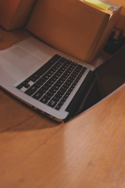 Girişim KOBİ küçük işletme girişimcisi önlük giyen Asyalı kadın dizüstü bilgisayar ve kutu kullanarak çevrimiçi müşterilere, çevrimiçi sme iş fikirlerine satış hazırlamak için siparişleri alır ve gözden geçirir.