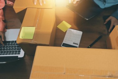 Girişim KOBİ küçük işletme girişimcisi önlük giyen Asyalı kadın dizüstü bilgisayar ve kutu kullanarak çevrimiçi müşterilere, çevrimiçi sme iş fikirlerine satış hazırlamak için siparişleri alır ve gözden geçirir.