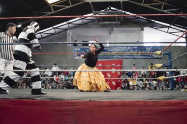 Male and female wrestlers in combat at the Cholitas Wrestling Event. October 14, 2012,  El Alto, La Paz, Bolivia. clipart