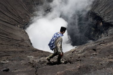 Aktif bir yanardağ Bromo Tengger Semeru Milli Parkı'nın kenarında yürüyen Tenggerese adam. 17 Ocak 2014 - Java, Endonezya