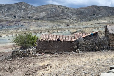 Jalq'a girl looking out from the roof of her adobe house located at Maragua Crater. October 6, 2012 - Maragua, Chuquisaca department, Bolivia clipart