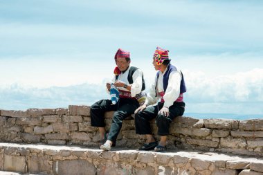 İki adam geleneksel kıyafetler Taquile Adası bölgesi onlardan bir şapka örgü belirli giymiş. Titicaca gölü, Peru - 17 Ekim 2012